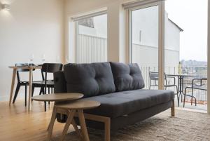 - un salon avec un canapé et une table dans l'établissement BmyGuest - Sao Vitor Balcony Apartment, à Porto