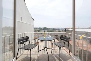 d'une terrasse avec une table et des chaises sur un balcon. dans l'établissement BmyGuest - Sao Vitor Balcony Apartment, à Porto