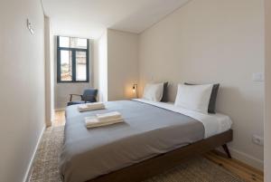 - une chambre avec un grand lit et 2 serviettes dans l'établissement BmyGuest - Sao Vitor Balcony Apartment, à Porto
