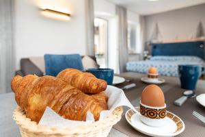 una mesa con una cesta de pan y huevos. en BAUR SUITE - Regarda Travel, en Bardolino