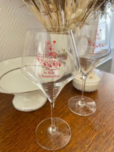 due bicchieri da vino seduti sopra un tavolo di La Cuvée , duplex à Gevrey Chambertin. a Gevrey-Chambertin