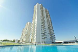 a large white apartment building with a swimming pool at Costa Mansa II, Avenida Costanera 3100 , Departamento 2201 in Coquimbo