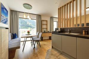 eine Küche mit einem Tisch und einem Esszimmer in der Unterkunft Haus St. Anton in Sankt Anton am Arlberg