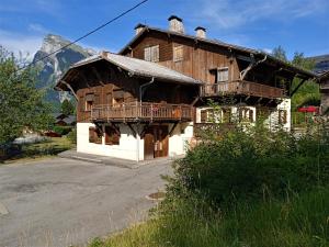 a large wooden house with a balcony in the mountains at Le Battieu in Samoëns