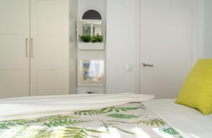 a bedroom with white cabinets and a bed with a yellow pillow at Sun, Sea, Beach Costa Calida Spain Henrys Apartment in Águilas