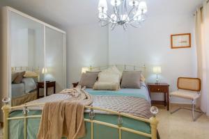 a bedroom with a bed and a chandelier at Sun, Sea, Beach Costa Calida Spain Henrys Apartment in Águilas