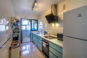 a kitchen with blue cabinets and a refrigerator at Sun, Sea, Beach Costa Calida Spain Henrys Apartment in Águilas