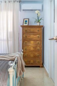 a bedroom with a wooden dresser with a plant on it at Sun, Sea, Beach Costa Calida Spain Henrys Apartment in Águilas