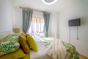 a bedroom with a bed with pillows and a window at Sun, Sea, Beach Costa Calida Spain Henrys Apartment in Águilas