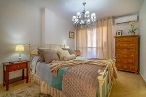 a bedroom with a bed and a chandelier at Sun, Sea, Beach Costa Calida Spain Henrys Apartment in Águilas