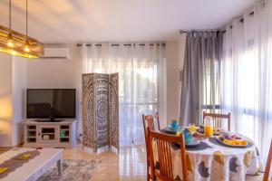 a living room with a dining room table and a television at Sun, Sea, Beach Costa Calida Spain Henrys Apartment in Águilas