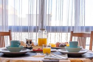 a table with plates of food and a bottle of orange juice at Sun, Sea, Beach Costa Calida Spain Henrys Apartment in Águilas