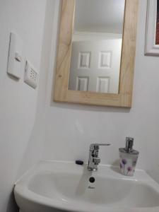 a bathroom with a white sink and a mirror at Hospedaje el Rosario in Angol +27 photos