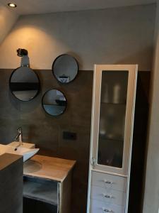 a bathroom with a sink and two mirrors on the wall at BNB DREAMS in Vorstenbosch