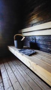 a bucket sitting on a wooden bench in a room at Venejoen Piilo - Kuohu in Kontiolahti