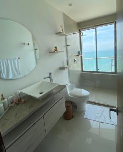 a white bathroom with a sink and a toilet at Paraíso frente al Mar Caribe en Cartagena. in Cartagena de Indias