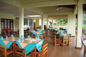a dining room with blue tables and chairs at Nature Walk Resort in Kandy