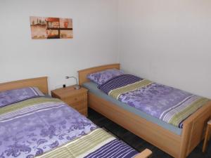 2 Einzelbetten in einem Schlafzimmer mit einem Bild an der Wand in der Unterkunft Apartment Hinrichs in Bad Zwischenahn