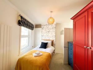 Schlafzimmer mit einem Bett und einem roten Schrank in der Unterkunft Premium Cheltenham Townhouse - By Suitely in Cheltenham