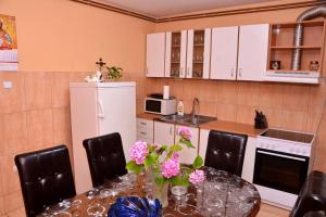 una cocina con una mesa con flores rosas. en IDILA, en Kladušnica