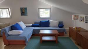 a living room with a blue couch and a table at Apartment Luna in Molunat