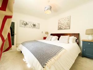 a bedroom with a large bed and a blue cabinet at Premium Cheltenham Townhouse - By Suitely in Cheltenham
