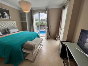 Un dormitorio con una gran cama verde y una ventana en Villa Maracana, en Marbella