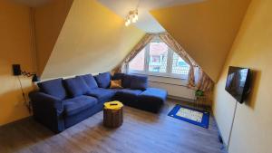 un soggiorno con divano blu e TV di Friesenmeer Ferienwohnung Drei a Bensersiel