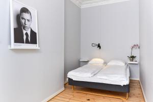 Bett in einem Zimmer mit einem Bild an der Wand in der Unterkunft Forenom Serviced Apartments Oslo Royal Park in Oslo