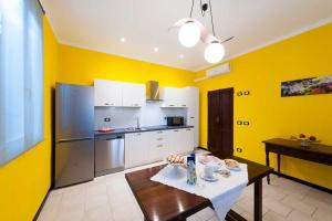 a kitchen with yellow walls and a table in it at B&B LA QUERCIA DI MERY in Ravarino