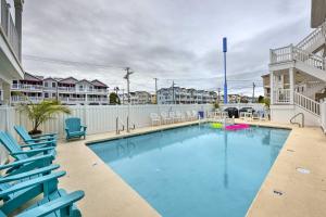 a swimming pool with blue chairs and a swimming poolvisorvisor at Wildwood Condo with Pool Access - Walk to Beach in Wildwood