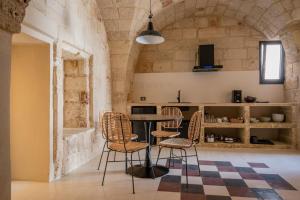 Una cocina con una mesa y sillas en una habitación. en le CASINE di MARUGGIO 4, en Maruggio
