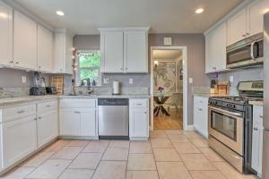 a large white kitchen with white cabinets and appliances at Whimsical Sacramento Home with Garden and Patio! in Sacramento