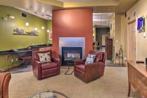 a living room with two chairs and a fireplace at Idyllic Dtwn Anchorage Condo with Fireplace! in Anchorage
