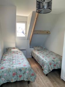 two beds in a room with a staircase at Maison vélo piscine tennis in Deauville +12 photos