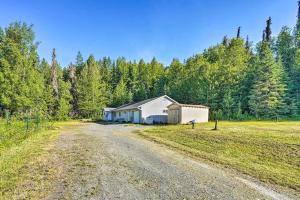 a barn in a field next to a dirt road at Single-Story Soldotna Home Near the Kenai River! in Soldotna