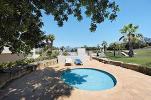- une piscine avec 2 chaises longues dans la cour dans l'établissement Pestana Gramacho Residence T2, à Carvoeiro