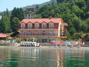 a large building on the shore of a body of water at Villa Cvet Rooms in Ohrid
