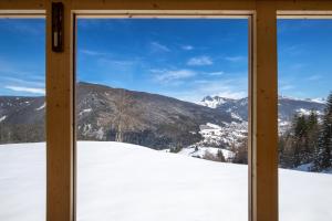 okna z widokiem na pokrytą śniegiem górę w obiekcie Chalet Alpina w mieście Ortisei