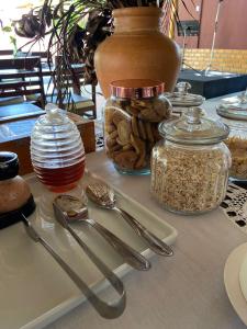 a table with utensils and jars and a vase at Pousada Paraiso - Santo Amaro Centro - perto de tudo in Santo Amaro +22 photos