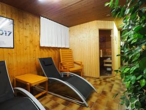 Zimmer mit einem Stuhl, einem Tisch und einem Stuhl in der Unterkunft Residenz La Mora in La Punt-Chamues-ch