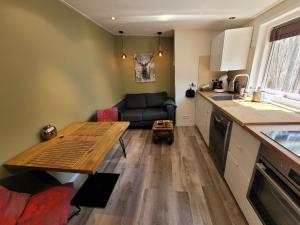 eine Küche und ein Wohnzimmer mit einem Tisch und einem Sofa in der Unterkunft Sleep Well Ness Domburg in Domburg