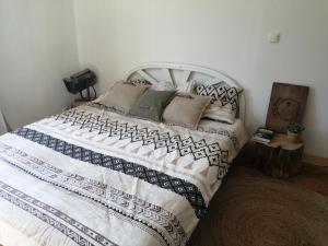 een slaapkamer met een bed met een wit en zwart dekbed bij La Canardière in Pendé