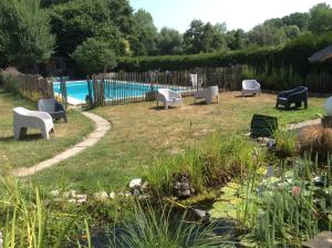 a yard with white chairs and a swimming pool at La Canardière in Pendé +42 photos