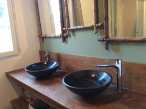 two sinks on a wooden counter in a bathroom at La Canardière in Pendé