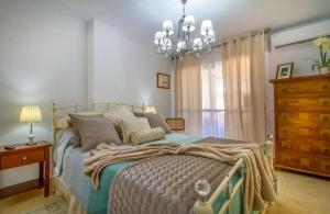 a bedroom with a large bed and a chandelier at Sun, Sea, Beach Costa Calida Spain Henrys Apartment in Águilas