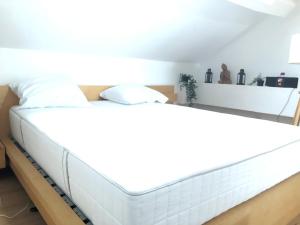 a large white bed in a room at FERTILE in Charleroi
