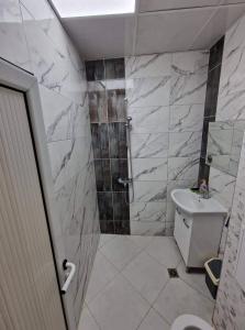 a bathroom with a toilet and a shower with marble walls at lux in Plovdiv