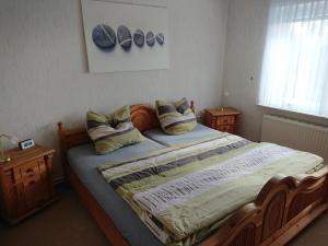 ein Schlafzimmer mit einem großen Bett mit Kissen darauf in der Unterkunft Frankenhuus in Krummhörn