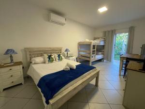 a bedroom with a bed with a blue blanket at Santa Hospedaria Beach in Bertioga